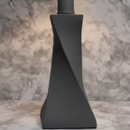 Soft warm lighting detail on modern twisted stone gray lamp base showing matte textured finish