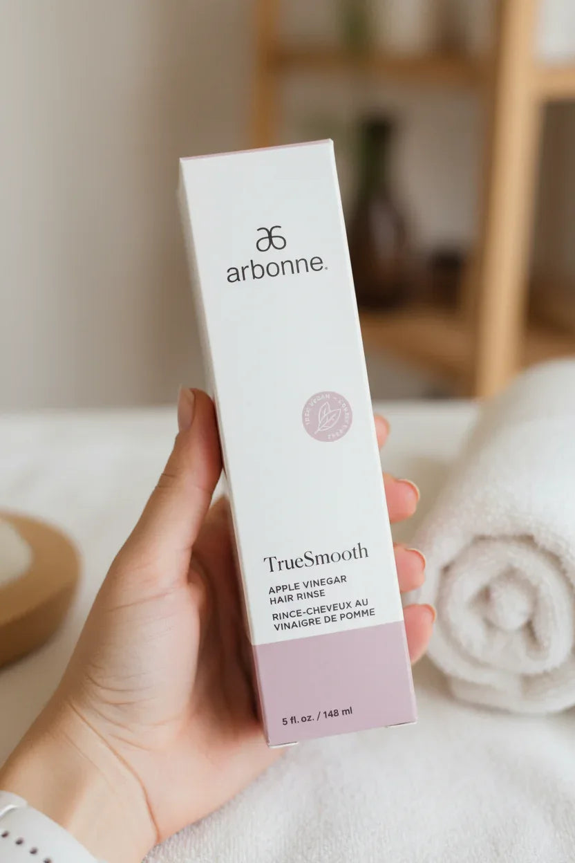 Arbonne TrueSmooth Apple Vinegar Hair Rinse in-hand close-up soft towel spa background