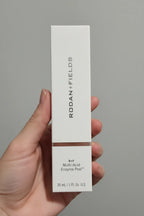 In-hand close-up of Rodan + Fields Multi-Acid Enzyme Peel box showing premium print texture and copper accent
