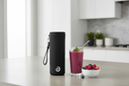 BlendJet JetSetter black insulated travel case on kitchen counter next to fresh frozen berries and smoothie glass