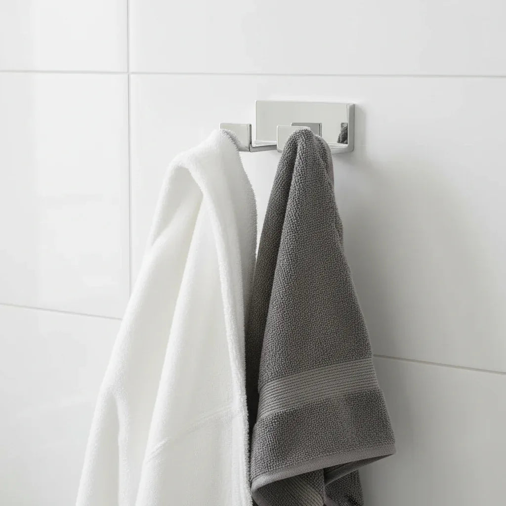 Modern minimalist bathroom with polished chrome double robe hook holding robe and towel