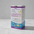 AI-generated contextual image of Nordic Naturals Complete Omega-D3 package at a three-quarter angle on a neutral surface