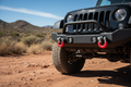 Daystar red D-ring shackle isolators installed on lifted Jeep Wrangler black bumper on dirt off-road trail - More4less Outlet
