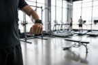 Person wearing black silicone smartwatch band on wrist while working out at a gym – fitness lifestyle photography