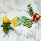 SuperBee Wax Wraps small triple pack flat lay on white marble with fresh vegetables herbs and lemon