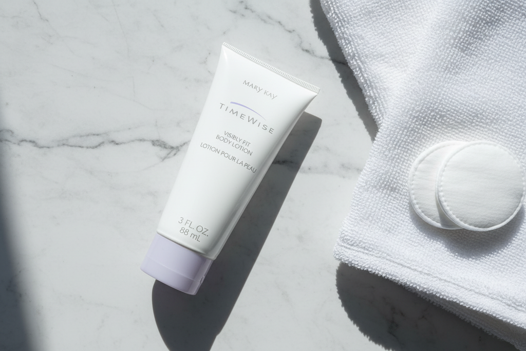 Mary Kay TimeWise Visibly Fit Body Lotion 3oz tube in morning skincare flat lay with white towel and cotton pads on marble