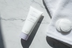 Mary Kay TimeWise Visibly Fit Body Lotion 3oz tube in morning skincare flat lay with white towel and cotton pads on marble