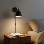 Globe Electric Lex matte black brass wall sconce mounted in bedroom above nightstand