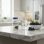 Nutricost Resveratrol bottle on white marble kitchen island with glass of water and bowl of grapes