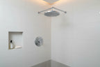 Modern spa-style bathroom with polished chrome round shower head and white tile walls