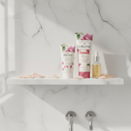 Minimalist rose beauty shelf with white skincare tubes, pink petals, and essential oil bottle in bright spa bathroom