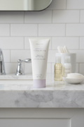 Mary Kay TimeWise Visibly Fit Body Lotion 3oz tube on marble bathroom vanity with travel skincare essentials
