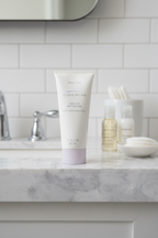 Mary Kay TimeWise Visibly Fit Body Lotion 3oz tube on marble bathroom vanity with travel skincare essentials
