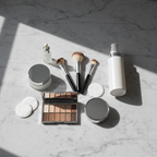 Luxury beauty vanity flatlay with skincare essentials on grey marble surface