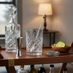Silver One cocktail mixer set arranged on dark-wood home bar cart with crystal decanter and fresh lime wedges