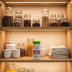 Rainbow Light Women's One Multivitamin bottle inside organized family health cabinet with recessed lighting and high-transparency glass containers