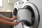 Person sliding a new lint filter into a dryer opening in a clean modern laundry room
