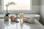 Clean spa-like bathroom setting displaying women's grooming essentials neatly arranged on white marble