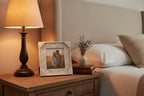 Rustic elegant bedside tabletop displaying a leaf-patterned distressed white picture frame
