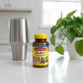 Nature Made Multi + Ashwagandha 60 Capsules on white quartz kitchen island with silver coffee tumbler and green houseplant