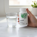 Hand holding Thorne Berberine bottle with green watercolor design beside glass of water on marble countertop morning wellness routine