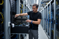 IT technician installing NVIDIA Tesla K40 GPU into rackmount server chassis in data center