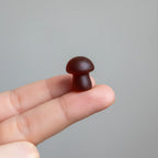 Close-up of dark mixed berry mushroom gummy on finger macro natural light