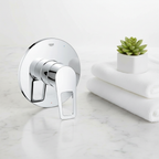 Grohe BauLoop polished chrome shower valve trim flat lay on white marble with folded white towels and small green plant