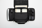 Interior of black laptop bag showing padded compartment and organized pockets with laptop, documents, and accessories