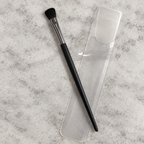 AI image of Mary Kay eye color brush on pale stone surface with clear sleeve