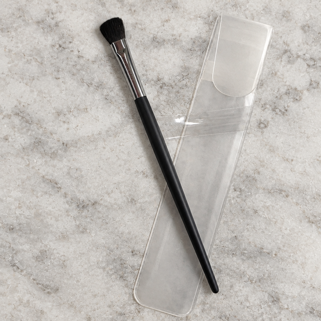 AI image of Mary Kay eye color brush on pale stone surface with clear sleeve