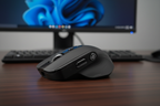 JLab Epic Mouse 2 wireless mouse 3/4 side view on dark wood executive desk