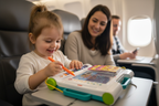 Child using Fisher-Price Learn and Doodle Desk on airplane tray table travel-friendly portable toy - More4less Outlet