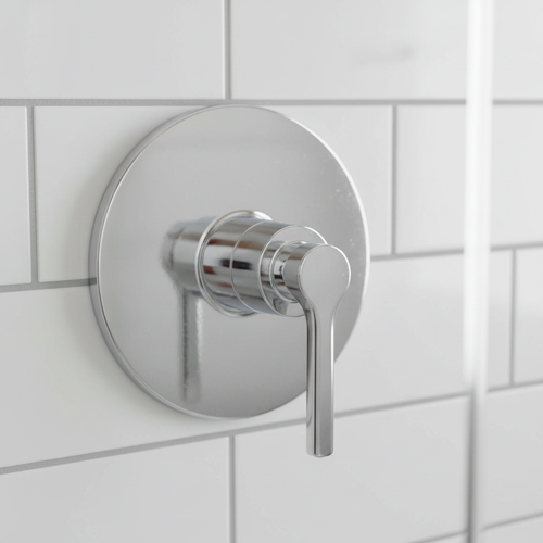 American Standard Studio S polished chrome pressure balance valve trim installed on a white subway tile shower wall.
