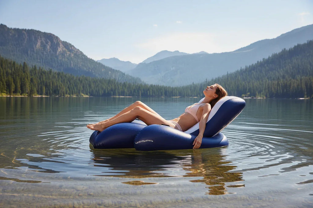Intex Floating Recliner Lounge woman sunbathing on calm mountain lake pine trees sunny summer day