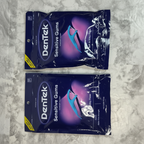 Two sealed DenTek Sensitive Gums Comfort Clean floss pick bags on a marble surface