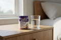 Natrol Magnesium Glycinate jar on oak bedside table with glass of water morning wellness lifestyle