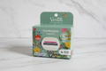 Gillette Venus Comfortglide Sugarberry Rifle Paper Co. 4-count refill box held against white marble tile — sage green with colorful botanical floral illustration