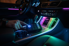 Person pressing power button on multi-channel LED controller inside vehicle with vibrant LED strip lights illuminating center console
