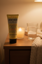Adamia hand cream on nightstand with candle and glass of water evening self-care routine