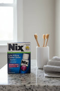 Nix Lice Killing Creme Rinse 2oz on gray granite bathroom counter with toothbrush holder and hand towel — More4less Outlet