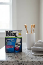 Nix Lice Killing Creme Rinse 2oz on gray granite bathroom counter with toothbrush holder and hand towel — More4less Outlet