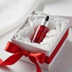 Lifestyle image - red glass skincare serum bottle in white gift box with satin ribbon, premium gifting editorial for visual context only