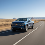 Chevrolet Silverado pickup truck driving confidently on smooth highway with clear blue sky