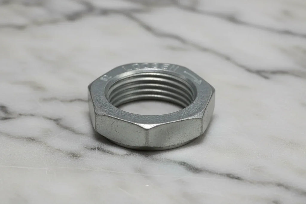 Industrial close-up of heavy-duty galvanized steel hex nut threading on marble background
