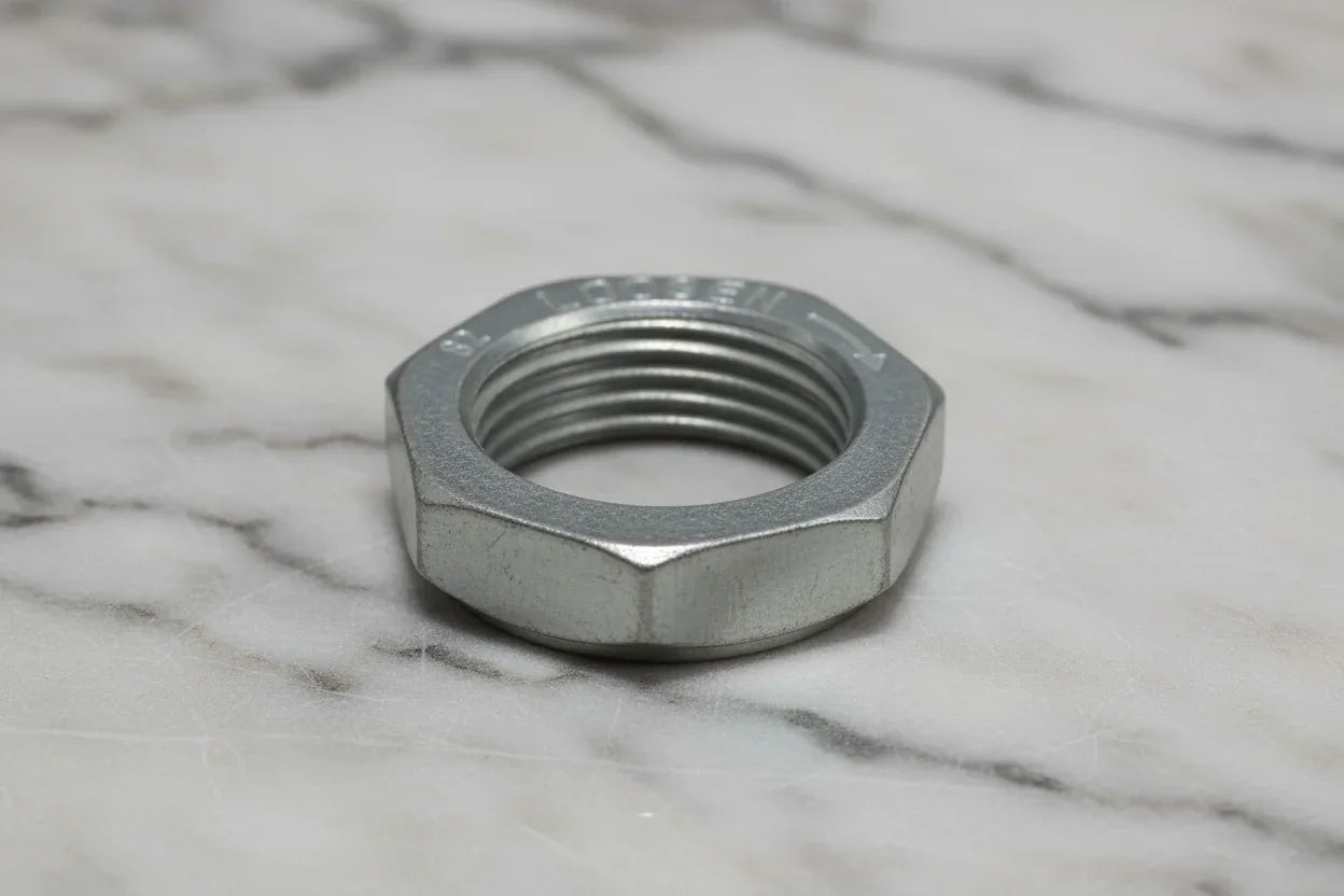 Industrial close-up of heavy-duty galvanized steel hex nut threading on marble background
