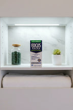 Focus Factor Extra Strength box on minimalist medicine cabinet shelf white lighting