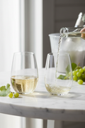Crisp Sauvignon Blanc white wine being poured into a Riedel The O stemless crystal wine tumbler on marble surface