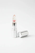 Single Firstfly Gold Foil Flowers color-changing lipstick on white studio background highlighting transparency and foil flakes