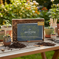 Inklings Paperie Gardening Journal gift set on outdoor potting table with small ceramic pots, organic soil, and gardening shears
